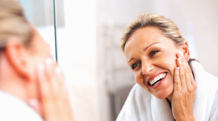 Smiling woman touching her face